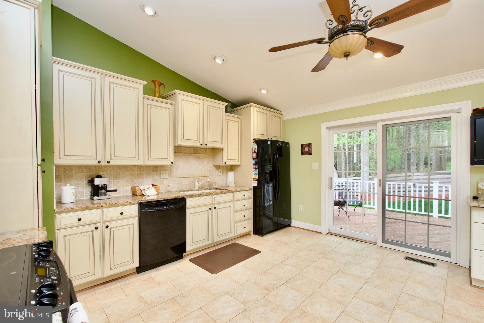 6690 Old Blacksmith Drive Burke, VA 22015 - Photo 13 of 46 a kitchen with stainless steel appliances granite countertop a refrigerator a sink and dishwasher with a dining table