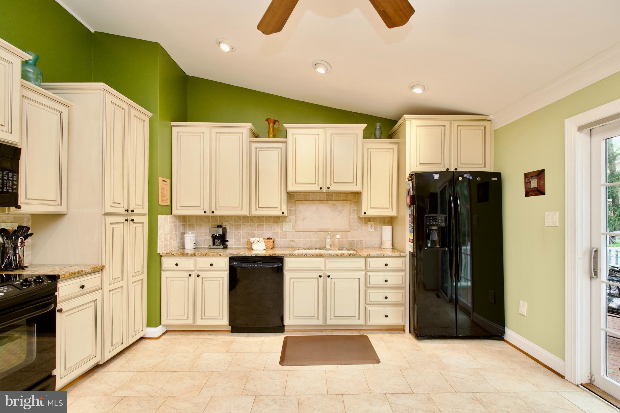 6690 Old Blacksmith Drive Burke, VA 22015 - Photo 14 of 46 a kitchen with stainless steel appliances granite countertop a refrigerator and a stove top oven