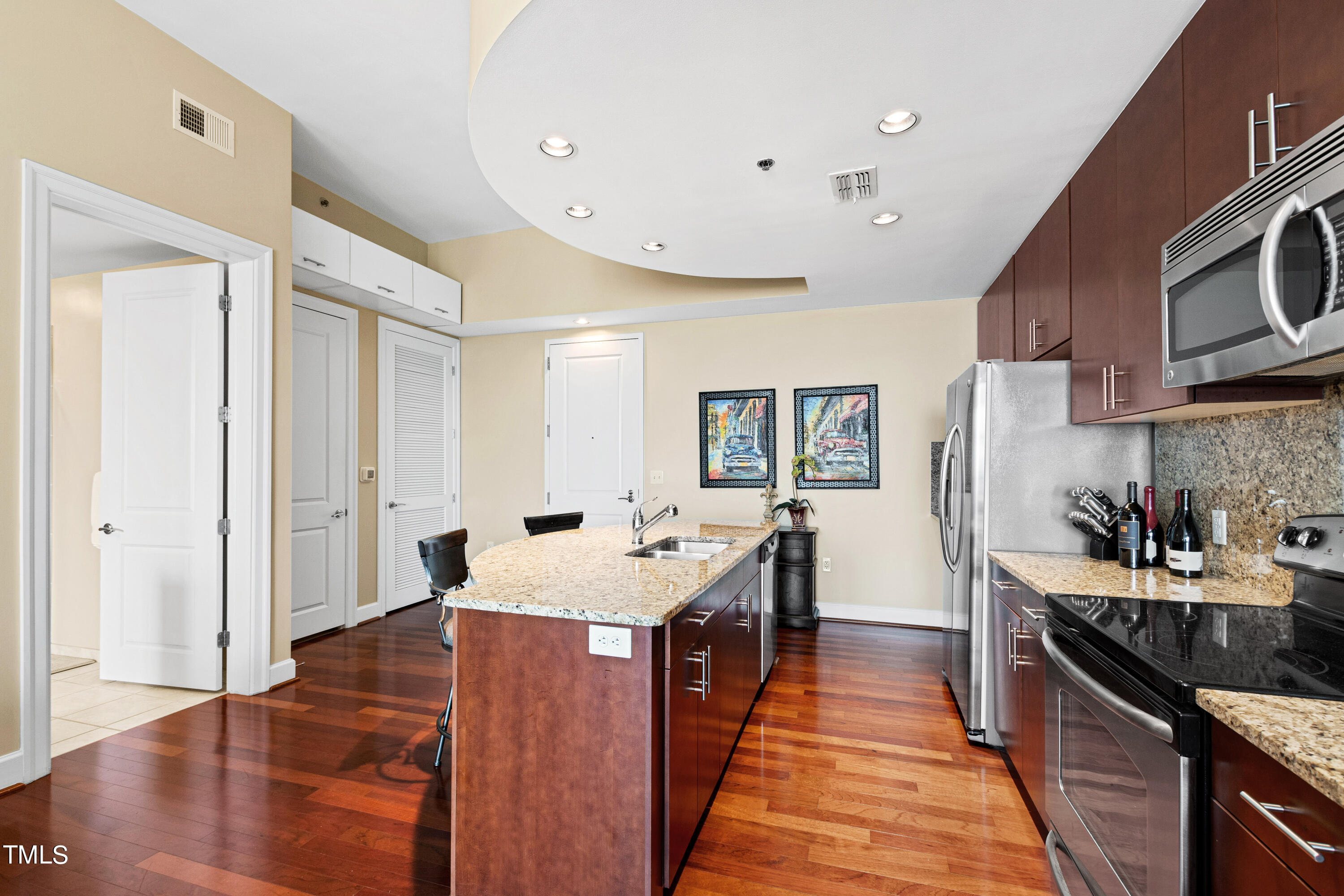 301 Fayetteville Street, Unit 3305 Raleigh, NC 27601 - Photo 14 of 80 a large kitchen with stainless steel appliances granite countertop a lot of counter space and wooden floor