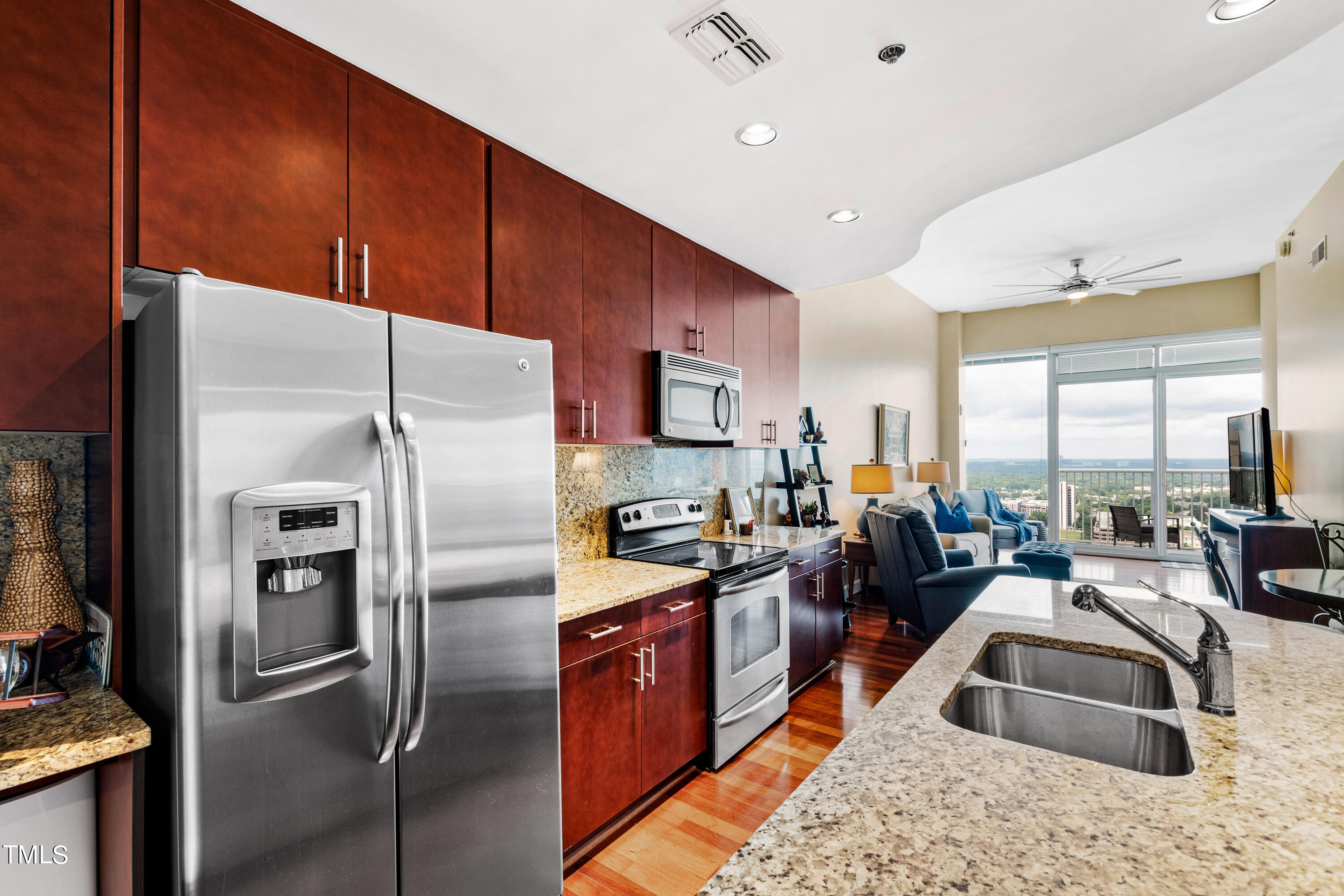 301 Fayetteville Street, Unit 3305 Raleigh, NC 27601 - Photo 17 of 80 a kitchen with stainless steel appliances granite countertop a refrigerator a sink a stove and a refrigerator with wooden floor