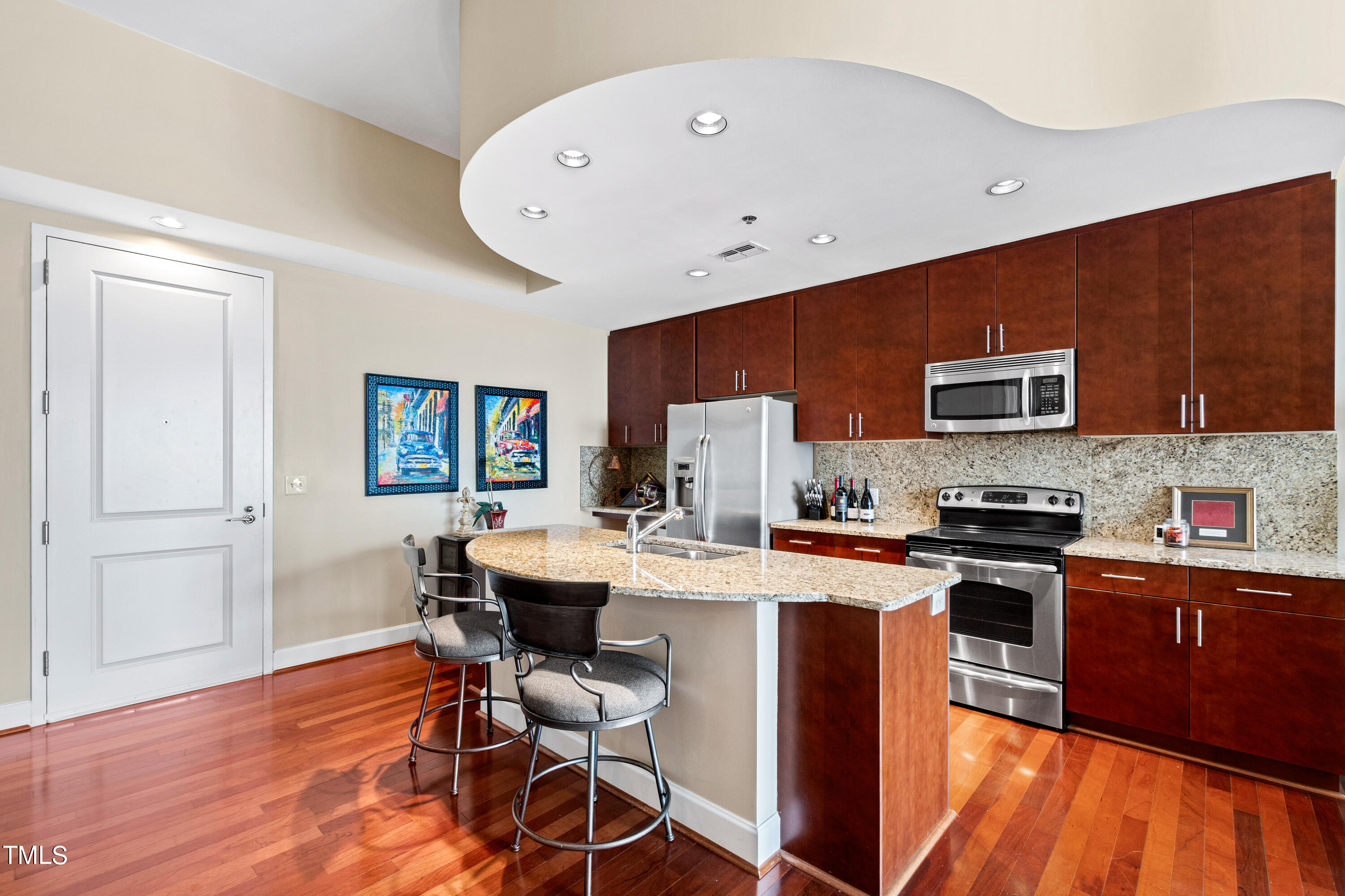 301 Fayetteville Street, Unit 3305 Raleigh, NC 27601 - Photo 10 of 80 a kitchen with stainless steel appliances granite countertop a stove top oven a sink dishwasher and a refrigerator with wooden floor