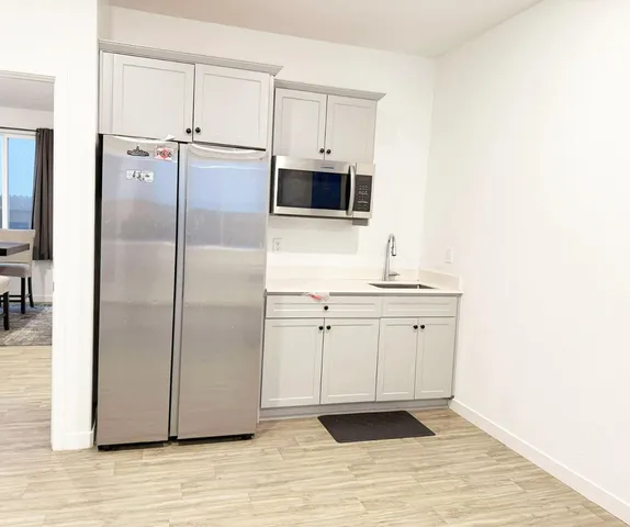 a kitchen with stainless steel appliances a refrigerator sink and microwave