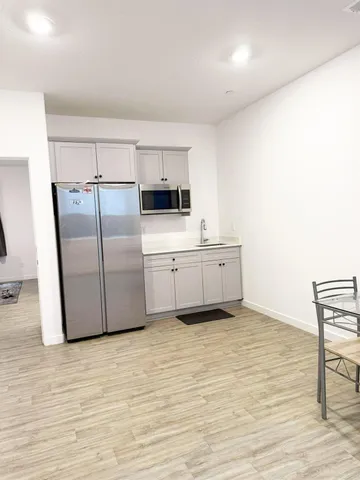 a kitchen with stainless steel appliances a refrigerator sink and cabinets