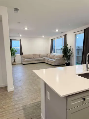 a view of living room with kitchen island furniture and wooden floor