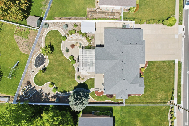 776 Flint Street Layton, UT 84041 - Photo 2 of 41 Expansive backyard featuring a manicured lawn, paved patio, and decorative stone pathways
