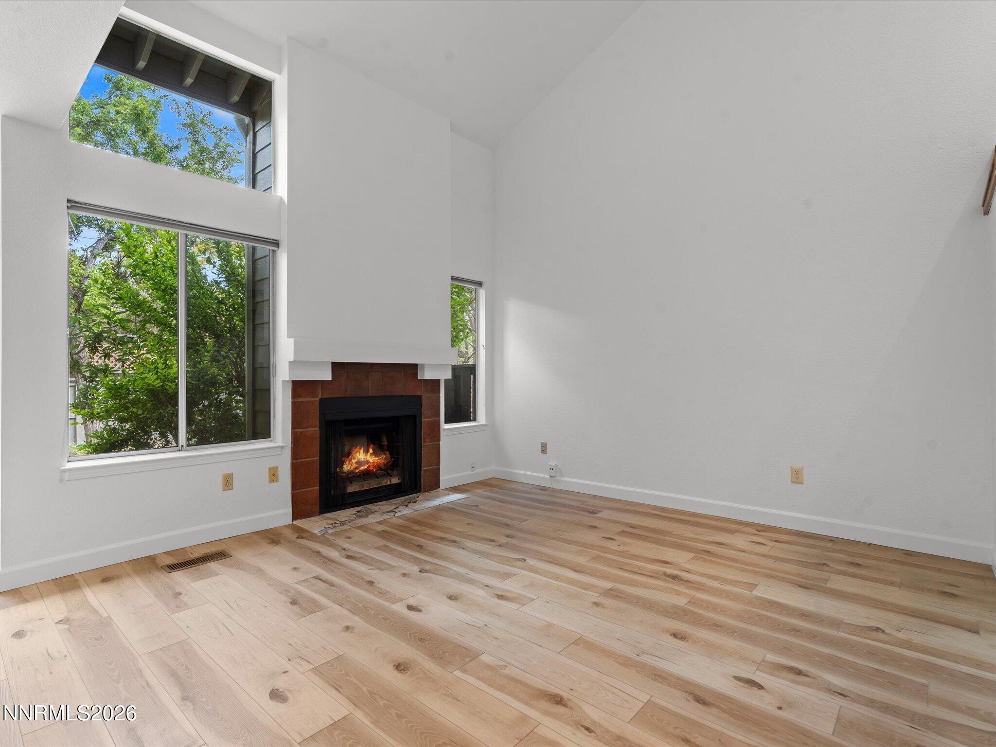 3170 Oakshire Court Reno, NV 89509 - Photo 9 of 43 a view of an empty room with wooden floor fireplace and a window
