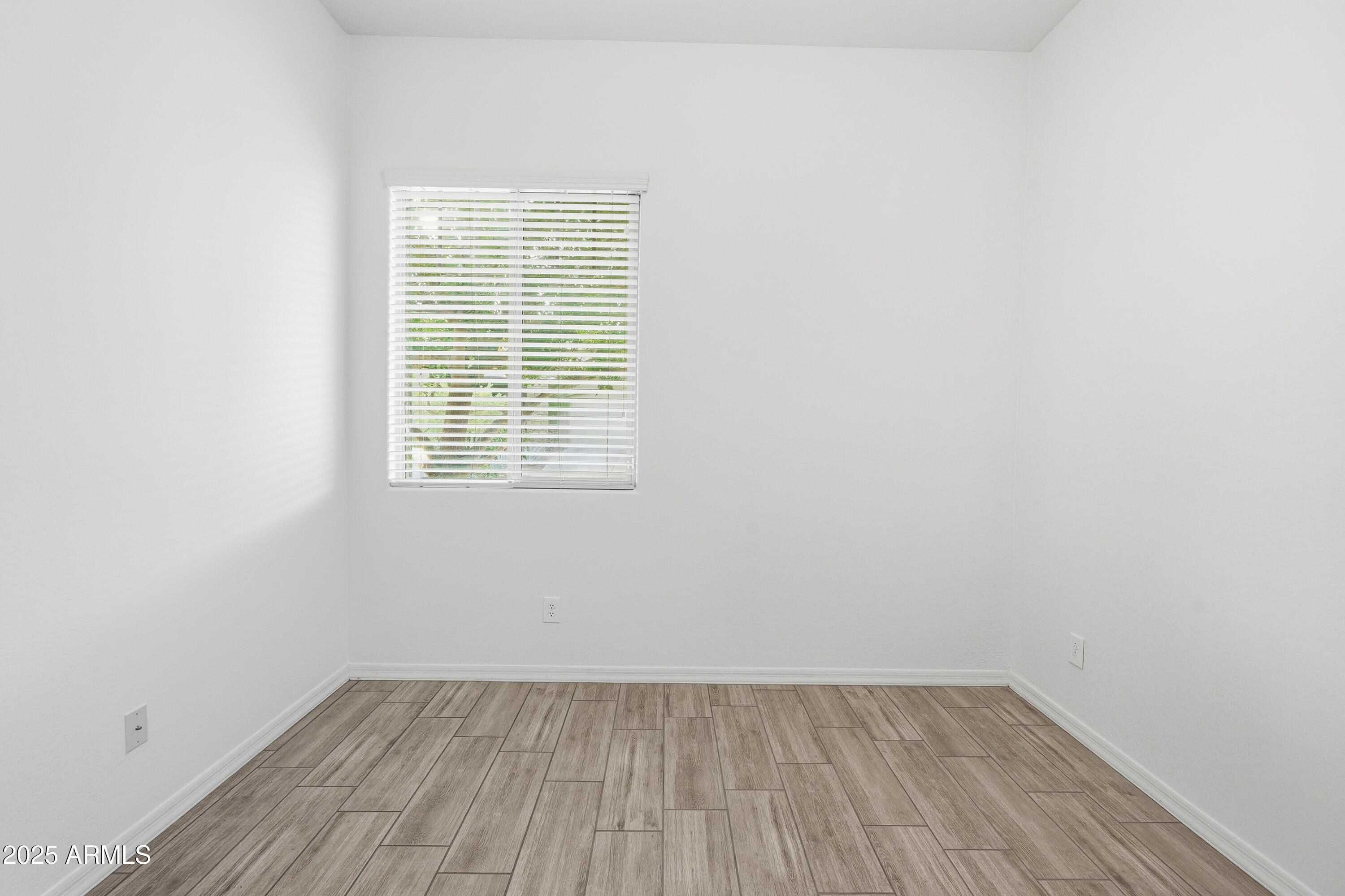 1432 East Pedro Road Phoenix, AZ 85042 - Photo 19 of 52 a view of an empty room with wooden floor and a window