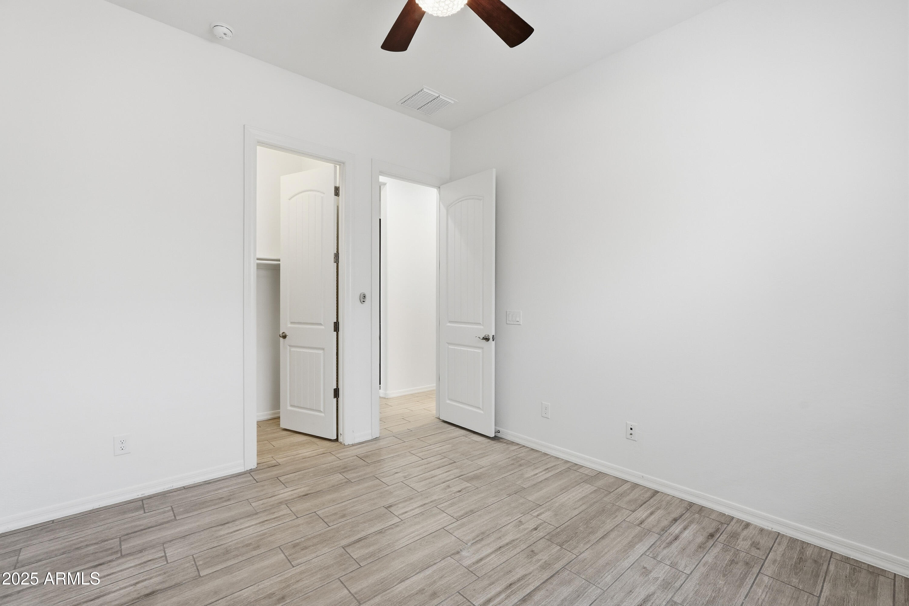 1432 East Pedro Road Phoenix, AZ 85042 - Photo 21 of 52 an empty room with closet and a chandelier fan