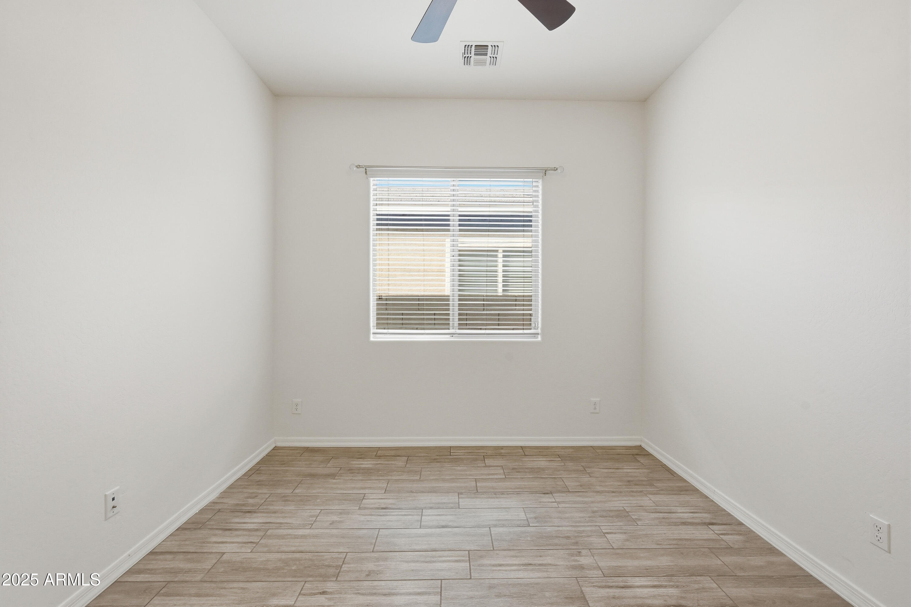 1432 East Pedro Road Phoenix, AZ 85042 - Photo 22 of 52 a view of empty room with wooden floor and fan