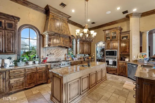 a kitchen that has a lot of cabinets in it and stainless steel appliances