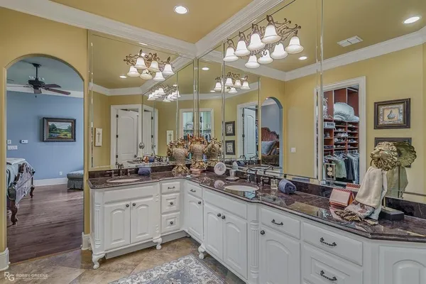 a bathroom with double vanity sinks a vanity a lamp and a mirror