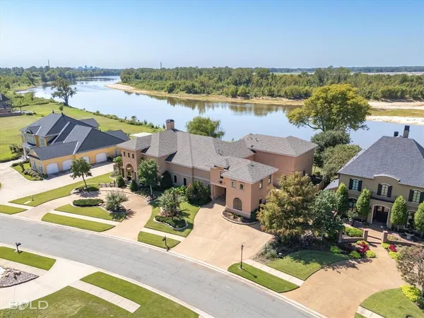 an aerial view of residential houses with outdoor space and ocean view
