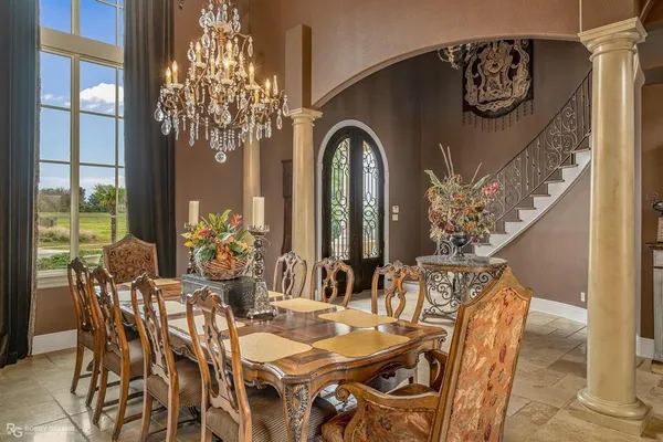 a dining room with furniture a chandelier and wooden floor