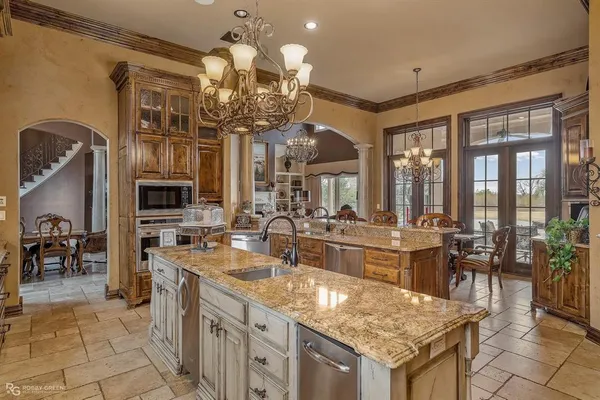 a kitchen with granite countertop a sink counter top space appliances and cabinets