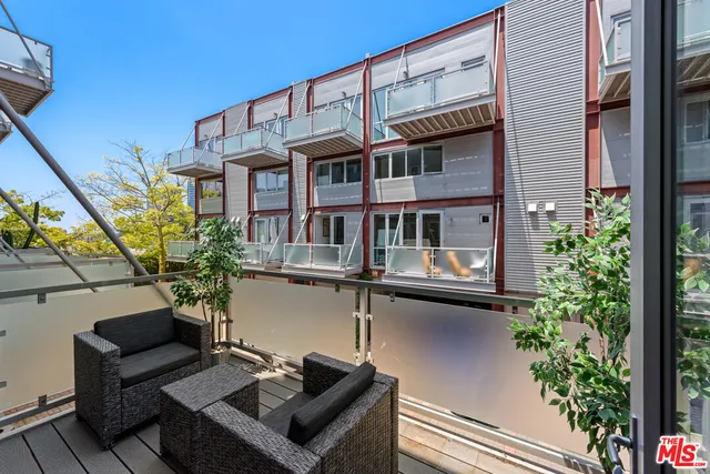 a view of a building with a large window and potted plants