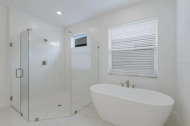 a white bath tub sitting next to a shower