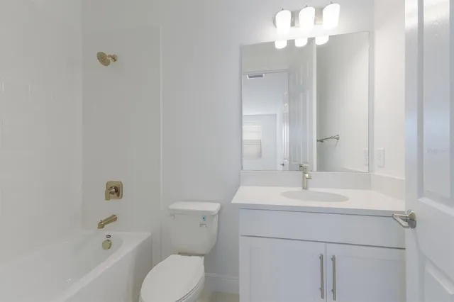 a bathroom with a sink a toilet a large mirror and shower