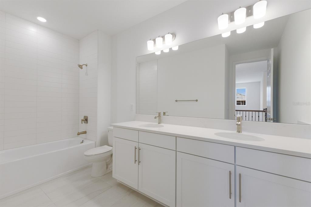 4611 Sweet Retreat Run Lakewood Ranch, FL 34211 - Photo 28 of 37 a bathroom with a sink a toilet a large mirror and shower