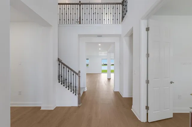 a view of a hallway with wooden floor and entryway