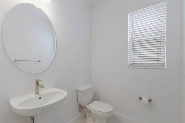 a bathroom with a sink a mirror and a toilet