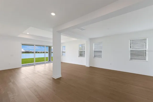 a view of an empty room with a fireplace and wooden floor