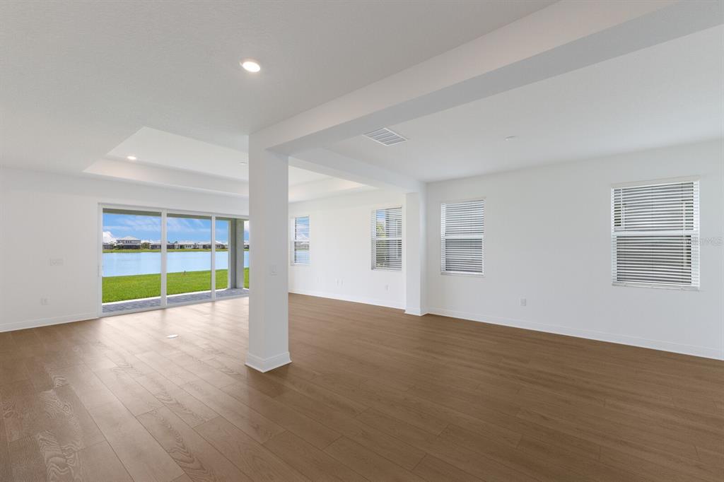 4611 Sweet Retreat Run Lakewood Ranch, FL 34211 - Photo 10 of 37 a view of an empty room with a fireplace and wooden floor