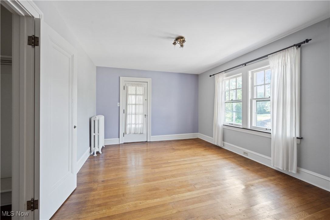 24510 Lake Road Bay Village, OH 44140 - Photo 37 of 45 Empty room with light wood-style floors and radiator
