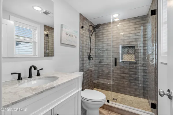 a bathroom with a sink a toilet and shower