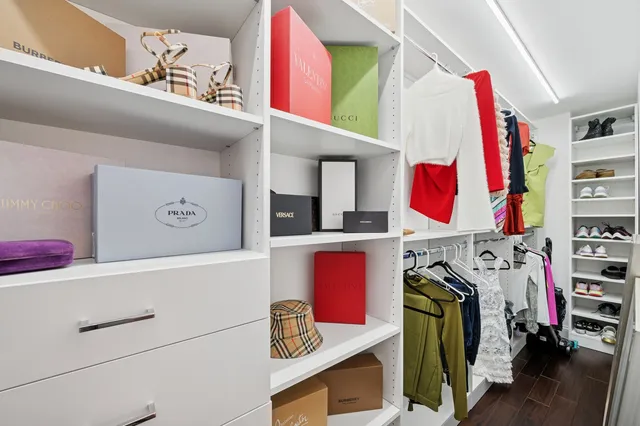 a view of walk in closet with clothes and shoes