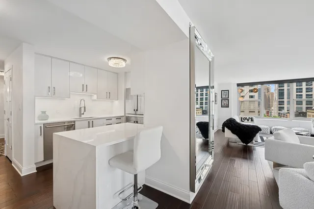 a living room with stainless steel appliances furniture and a large window