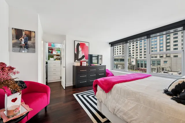 a bedroom with a bed dresser and a large window