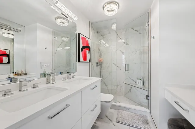 a bathroom with a double vanity sink mirror and toilet