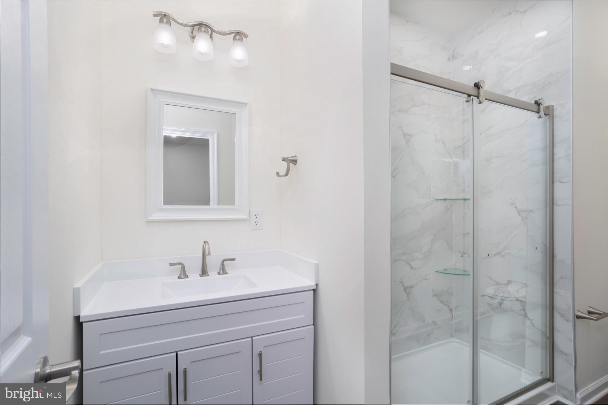 453 Willis Street Cambridge, MD 21613 - Photo 12 of 18 a bathroom with a shower a sink and mirror