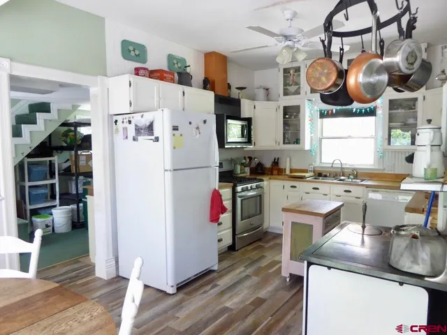 a kitchen with stainless steel appliances granite countertop a sink a stove and a refrigerator