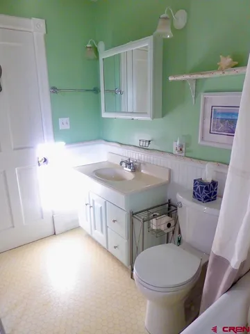 a bathroom with a sink mirror vanity and toilet