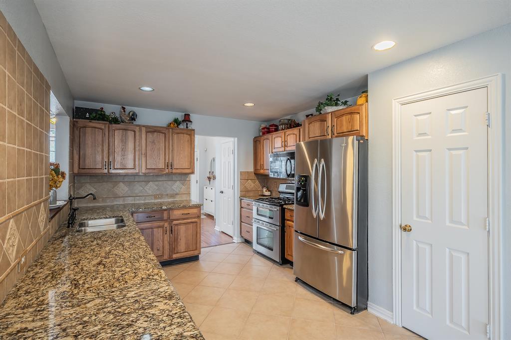 4425 Maple Shade Avenue Sachse, TX 75048 - Photo 11 of 40 a kitchen with a refrigerator sink and stove