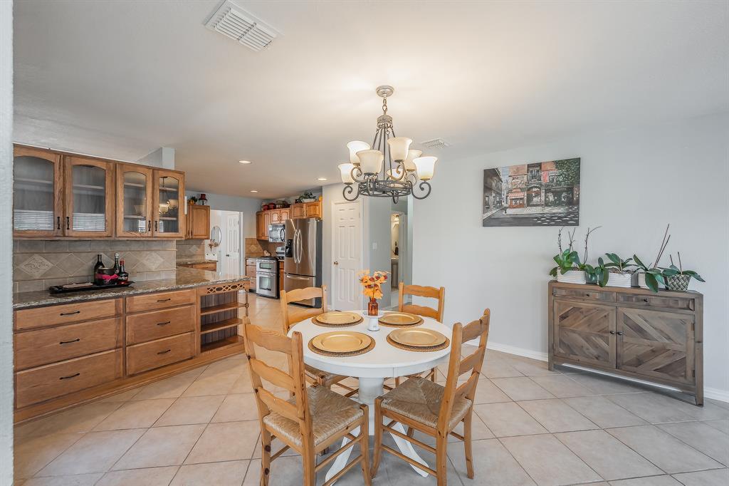4425 Maple Shade Avenue Sachse, TX 75048 - Photo 13 of 40 a view of a dining room with furniture and chandelier
