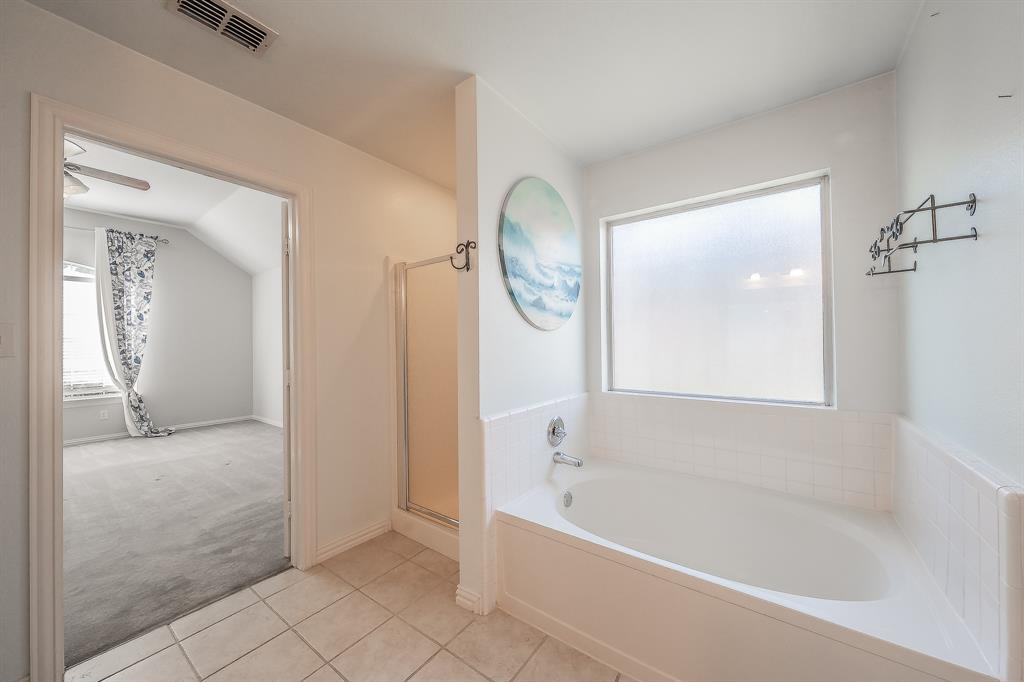 4425 Maple Shade Avenue Sachse, TX 75048 - Photo 21 of 40 a bathroom with a bathtub a mirror a vanity and a shower