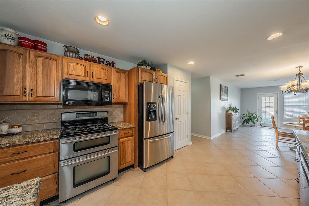 4425 Maple Shade Avenue Sachse, TX 75048 - Photo 10 of 40 a kitchen with stainless steel appliances a refrigerator and a stove top oven