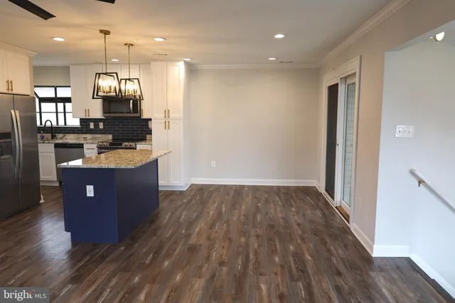 a open kitchen with wooden floors and a sink
