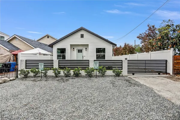 a view of a house with a yard and large tree