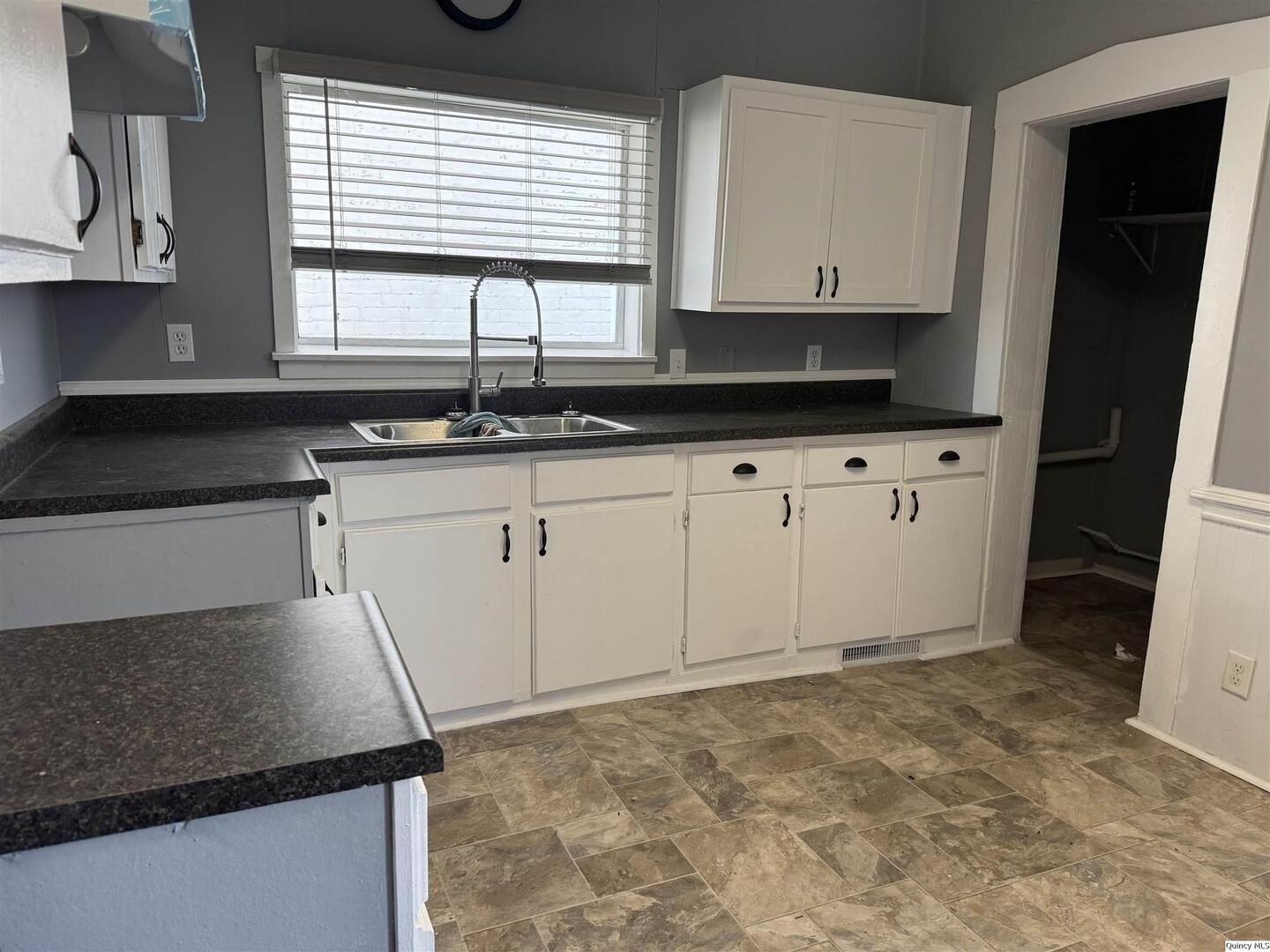 605 Adams Street Quincy, IL 62301 - Photo 3 of 15 a kitchen with granite countertop a sink and a stove