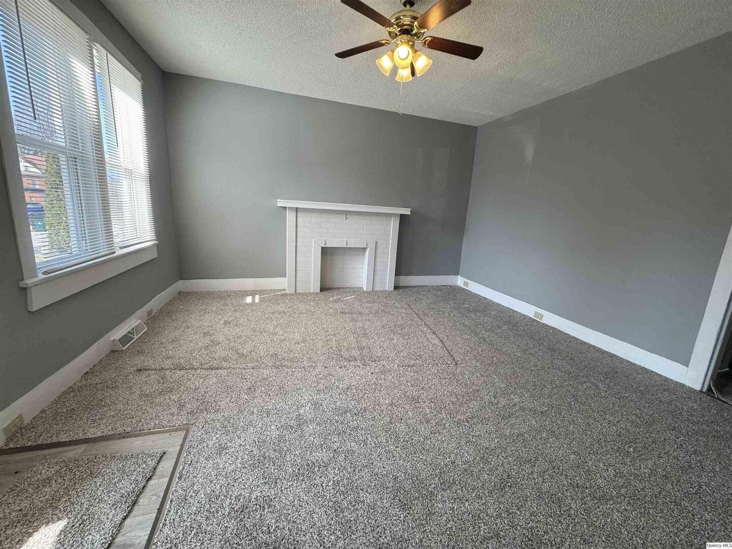 605 Adams Street Quincy, IL 62301 - Photo 4 of 15 an empty room with windows and chandelier fan