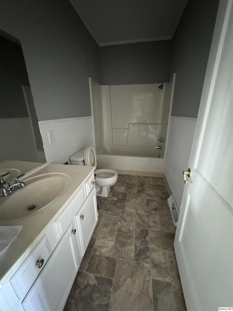605 Adams Street Quincy, IL 62301 - Photo 10 of 15 a bathroom with a granite countertop sink and a toilet