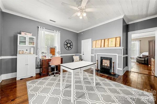 a view of a hallway with wooden floor and windows
