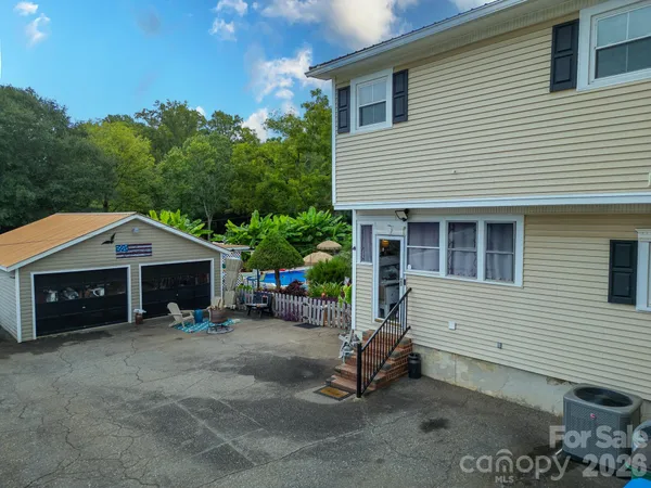a view of a swimming pool with some plants and large trees