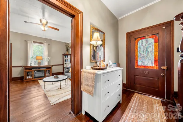 a view of an entryway with wooden floor and livingroom view