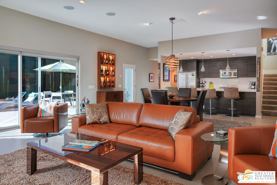 1069 Dane Drive Palm Springs, CA 92262 - Photo 27 of 51 a living room with furniture a kitchen view and a chandelier