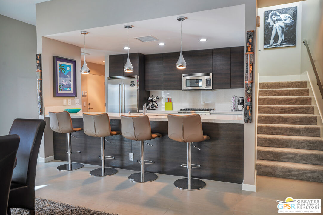 1069 Dane Drive Palm Springs, CA 92262 - Photo 38 of 51 a kitchen with a dining table chairs and white cabinets