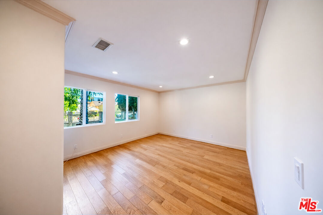 13847 Gilmore Street Van Nuys, CA 91401 - Photo 12 of 43 an empty room with wooden floor and windows